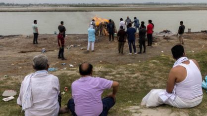Familiares observam cremação de homem que morreu de Covid-19 às margens do rio Ganges no Estado indiano de Uttar Pradesh